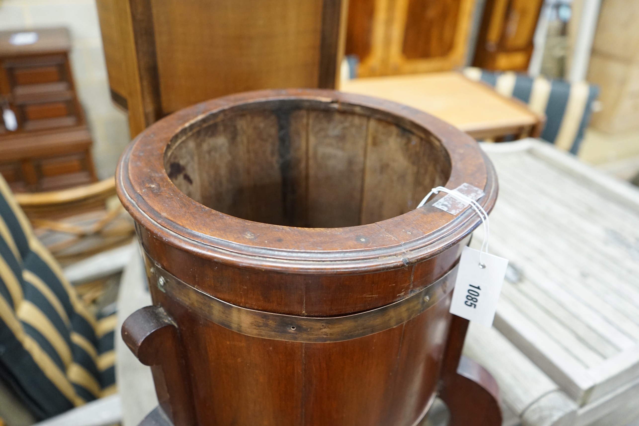 An Arts and Crafts brass bound staved mahogany circular jardiniere, diameter 35cm, height 78cm